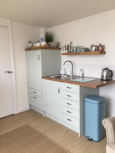 a kitchen with a sink and a counter top at 1-bedroom chalet with parking on site in Looe