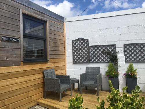 a patio with chairs and a table on a building at 1-bedroom chalet with parking on site in Looe