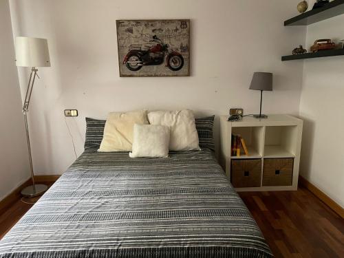 1 dormitorio con 1 cama con una motocicleta en la pared en APARTAMENTO GRANDE 2 HABITACIONES Y TERRAZA, en A Coruña
