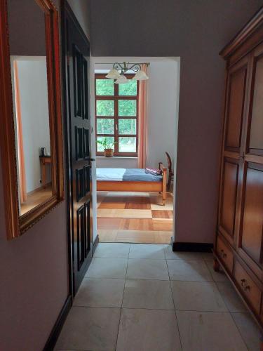a hallway with a room with a bed and a window at Pałac w Małkowie in Warta