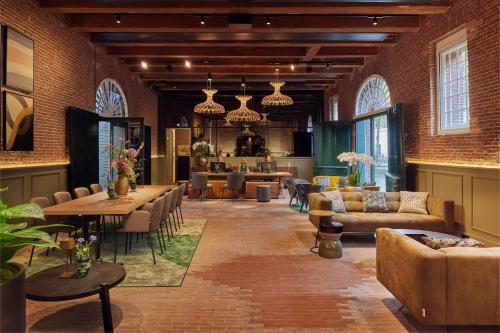 a living room with couches and tables and chairs at Hotel Arsenaal Delft in Delft