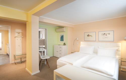 1 dormitorio con 1 cama blanca y 1 silla en Arthotel ANA Fleur, en Paderborn