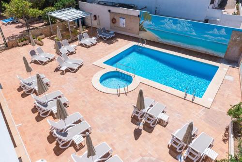 una vista aérea de una piscina con tumbonas y una piscina en Hotel Ses Puntetes, en Cala d´Or