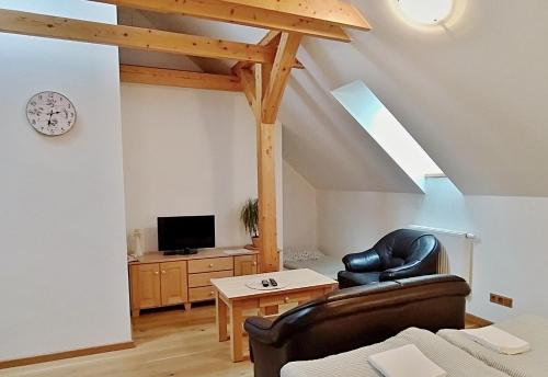 a living room with a couch and a tv at Penzion Kovárna in Bukvice