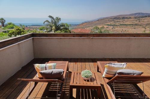 a patio with two chairs and a table on a roof at Agama in Livnim