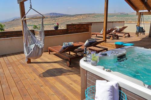 a patio with a hammock and a hot tub at Agama in Livnim