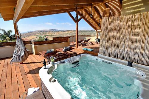 a jacuzzi tub on a deck with a view at Agama in Livnim