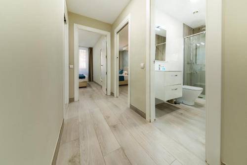 einen Flur mit einem Bad mit WC und Waschbecken in der Unterkunft Holidays2Malaga Suites in Málaga