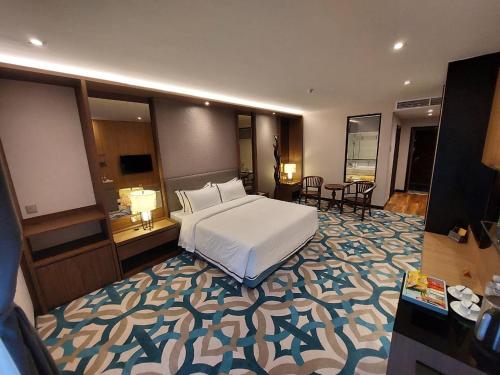a bedroom with a white bed and a large rug at CHRISTEE SUITES HOTEL in Melaka