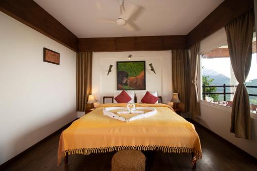a bedroom with a bed and a large window at Blackberry Hills Munnar Nature Resort & Spa in Munnar