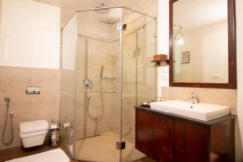 a bathroom with a shower and a sink and a toilet at Blackberry Hills Munnar Nature Resort & Spa in Munnar