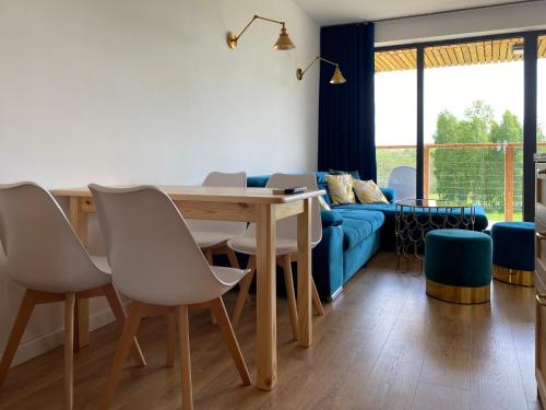 a living room with a table and a blue couch at Glemuria in Kętrzyn