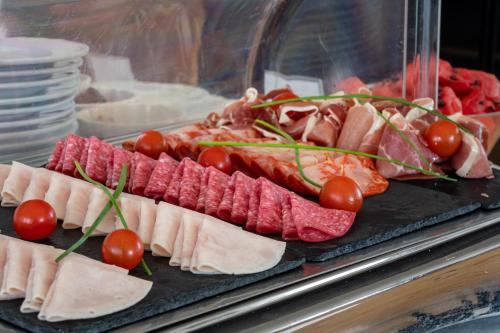 a tray of meats and tomatoes on a counter at Hotel do Chiado in Lisbon
