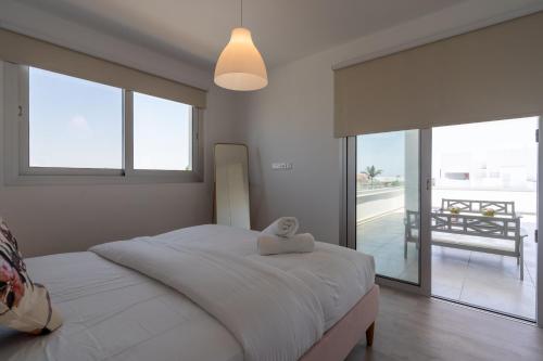 ラルナカにあるHarmonia 2-BR Apt in Livadiaのタオルが敷かれたベッドのある寝室