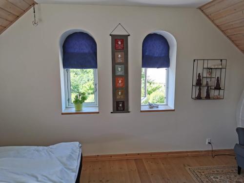 a bedroom with three windows and a bed at Safine B&B in Fåborg