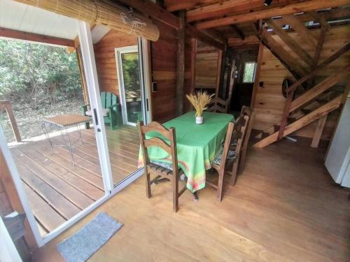 - une table et des chaises sur la terrasse couverte d'une cabine dans l'établissement Cabaña La Lechiguana, à Maldonado