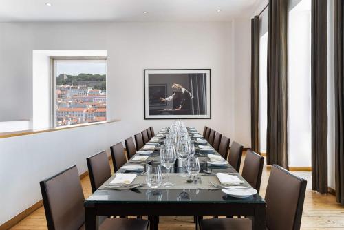 a long dining room with a long table and chairs at Hotel do Chiado in Lisbon