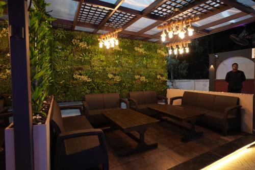 a man standing in a restaurant with a green wall at Bajaj's Karwan Inn in Jagdalpur