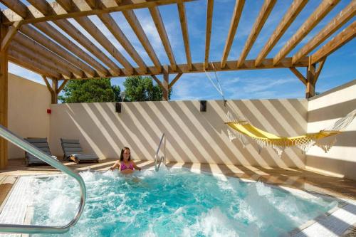 une femme se pose dans une piscine dans l'établissement Charmant Mobil-Home 6 pers, à Narbonne