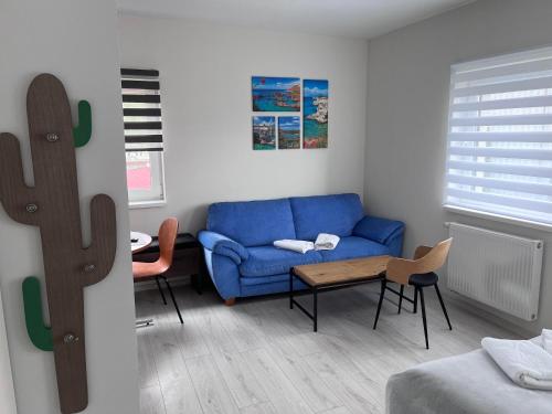 a living room with a blue couch and a table at Apartament Familijny przy ul. Spokojnej in Kołobrzeg