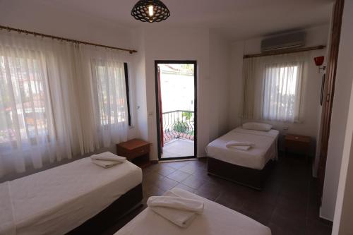 a bedroom with two beds and a door with a balcony at Monta Verde Hotel & Villas in Oludeniz
