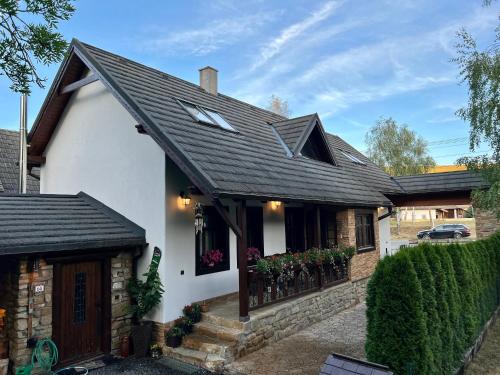 a white house with a black roof at Chalupa MATEJKO in Liptovský Mikuláš