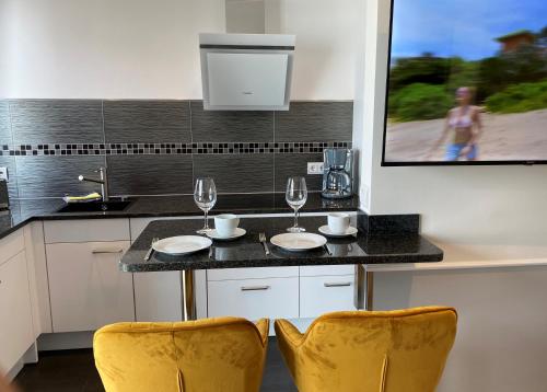 eine Küche mit einem Tisch mit 2 Stühlen und Weingläsern in der Unterkunft Hotel zum Hafen in Sassnitz
