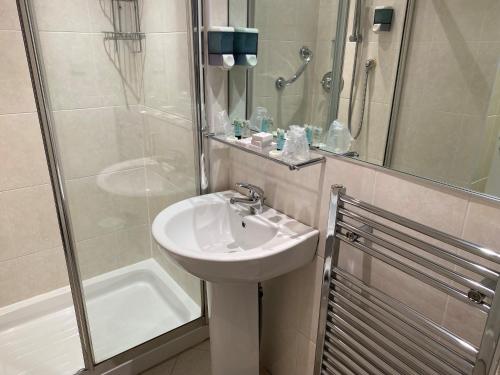 uma casa de banho com um lavatório e um chuveiro em Avonbridge Hotel em Hamilton