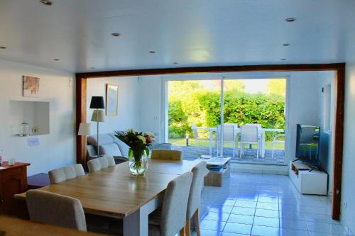 ein Wohnzimmer mit einem Esstisch und einem TV in der Unterkunft Le Cocon de la Mare in Les Granges