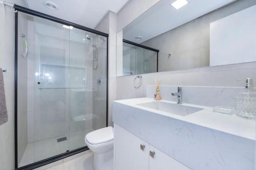 a bathroom with a shower and a sink and a toilet at Adra 106 - Apartamento no centro de Bombinhas - Rooftop com piscina e academia - À poucos metros da praia - (Consultar serviços de roupas de cama e banho) in Bombinhas