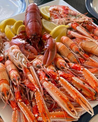 a plate of lobster and other seafood on a table at Holly Lodge - 2 x Kingsize bedrooms with private entrance and free parking-new shower room in Oban