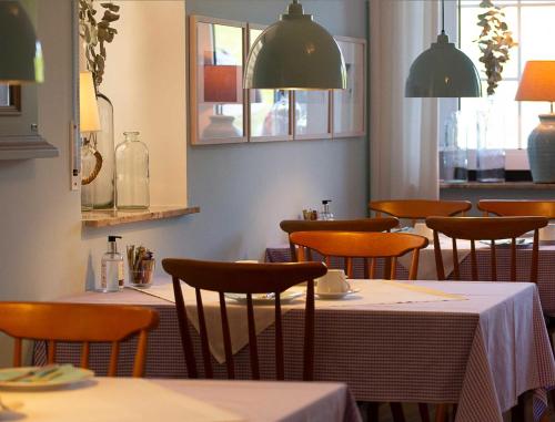 a dining room with tables and chairs and lights at Hus Kiek in de See in Cuxhaven