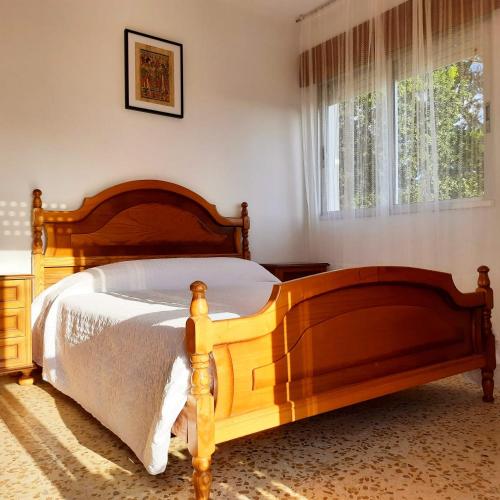 um quarto com uma cama de madeira e uma janela em Apartamentos Mar de Nanín em Sanxenxo