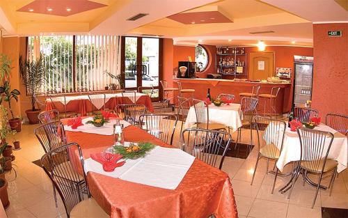 a dining room with tables and chairs in a restaurant at HOTEL PHILOXENIA in Eforie Nord