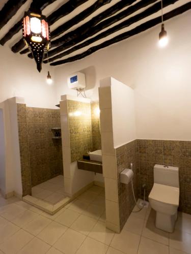 a bathroom with a toilet and a sink at Emerald Palm Courtyard Hotel in Zanzibar City