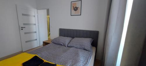 Apartament New Space 30% OFF, Self chieck-in, Netflix في جيشوف: سرير صغير ومخدتين عليه في غرفة