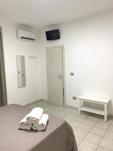 a bedroom with a bed with two towels on it at House Torre Galea in Marina di Gioiosa Ionica