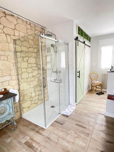 a glass shower in a bathroom with a stone wall at Apartamentos LA SOMERA in Alhama de Aragón