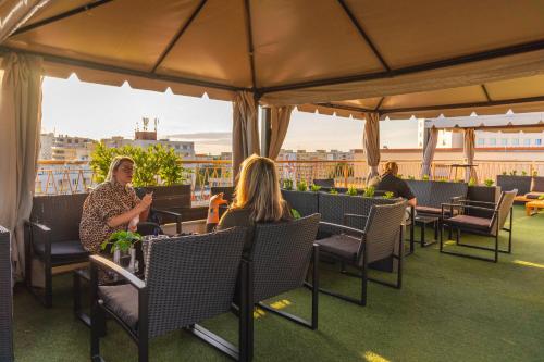 people sitting at tables on the roof of a building at Spa Hotel Vita in České Budějovice