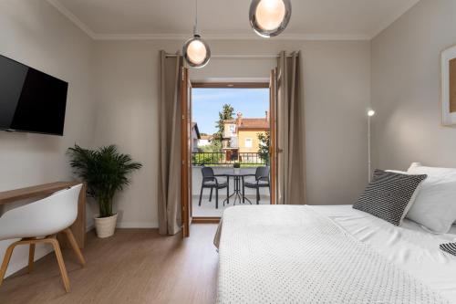 a bedroom with a bed and a balcony with a table at Apartments Alloro by SeeAdria Agency in Novigrad Istria
