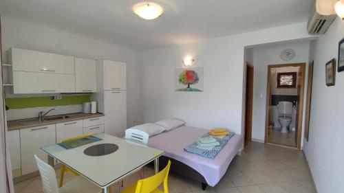 een kleine kamer met een tafel en een keuken bij Rogoznica Seafront Apartment - Kalebova Luka in Rogoznica