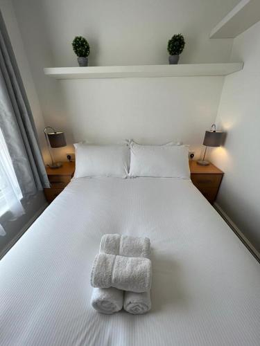 sypialnia z białym łóżkiem i ręcznikami w obiekcie Bridge Terrace A w Southampton