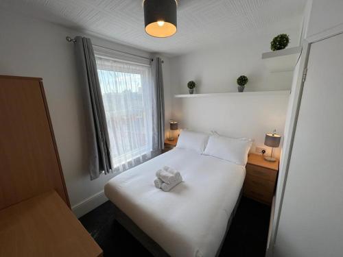 sypialnia z białym łóżkiem z pluszakiem w obiekcie Bridge Terrace A w Southampton