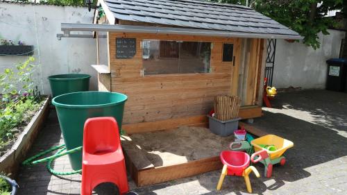 a small wooden dog house with chairs and a sandbox at Ferienwohnung Rosenstadt in Forst