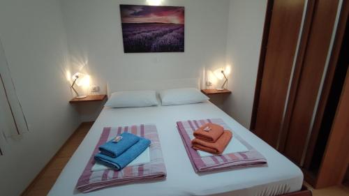 1 dormitorio con 1 cama con 2 toallas en Rogoznica Seafront Apartment - Kalebova Luka, en Rogoznica