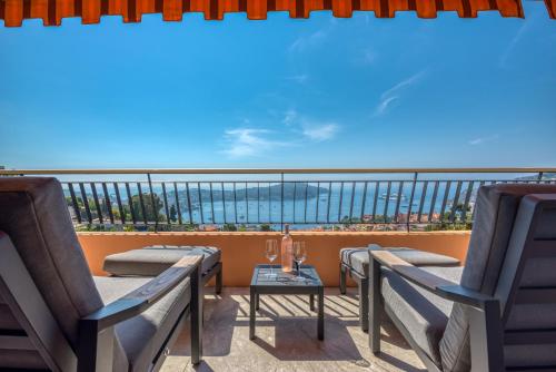 a balcony with chairs and a table with a view of the ocean at Villefranche Bay View in Villefranche-sur-Mer