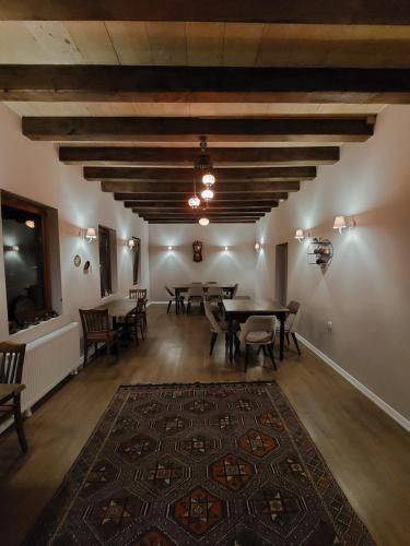 a dining room with tables and chairs and a rug at Grand Uchisar Hotel in Uchisar