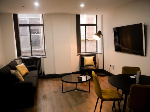 a living room with a couch and a table at New Oxford House Apartments By Happy Days in Liverpool