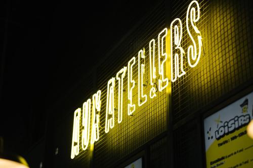 a neon sign on the side of a building at Aux Ateliers in Miserey-Salines