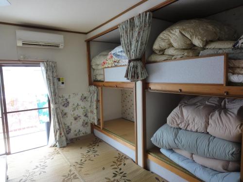 a room with bunk beds and a window at Wataya Inn in Fujisawa